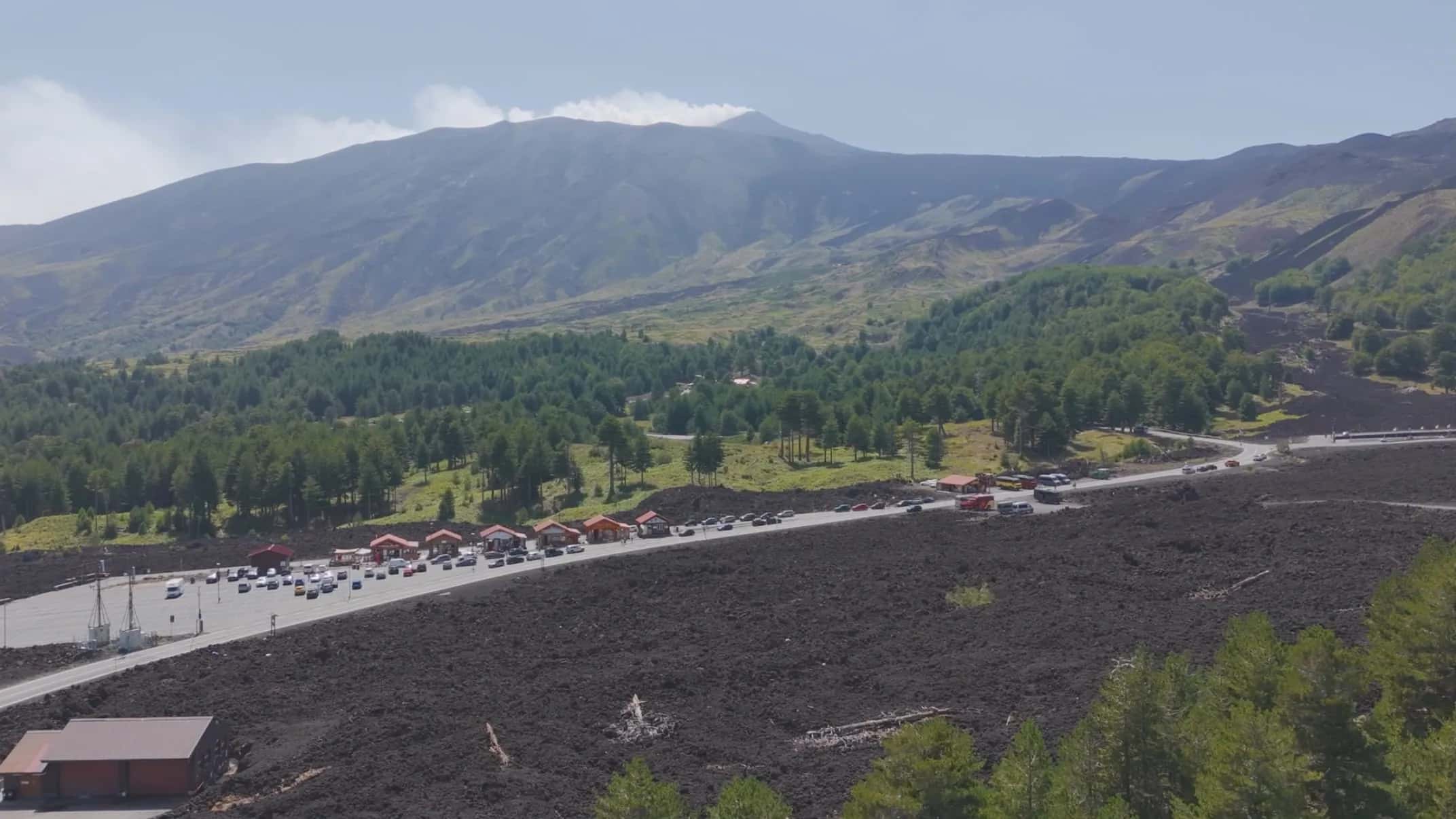Il piazzale di Piano Provenzana tra la pineta e la colata lavica, con l'Etna sullo sfondo