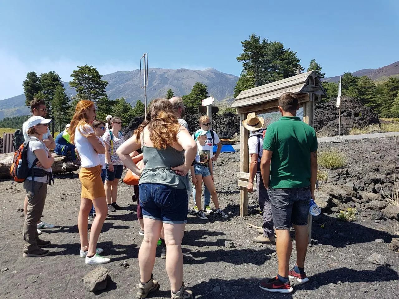 Il gruppo al pannello informativo all'inizio del sentiero, con l'Etna alle spalle