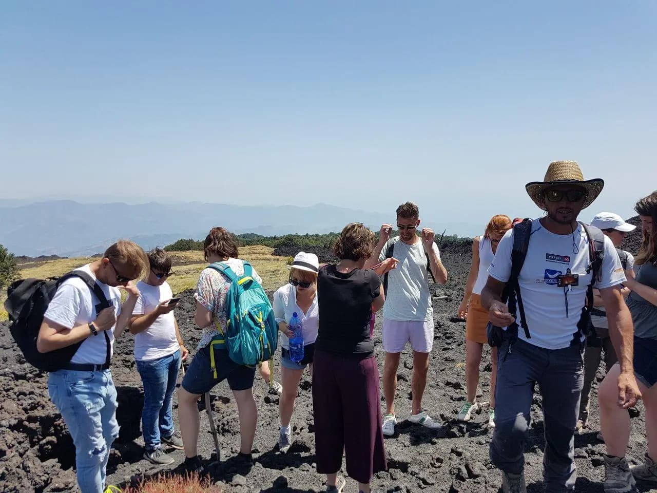 La guida racconta l'eruzione al gruppo, in piedi sulla lava del 2002