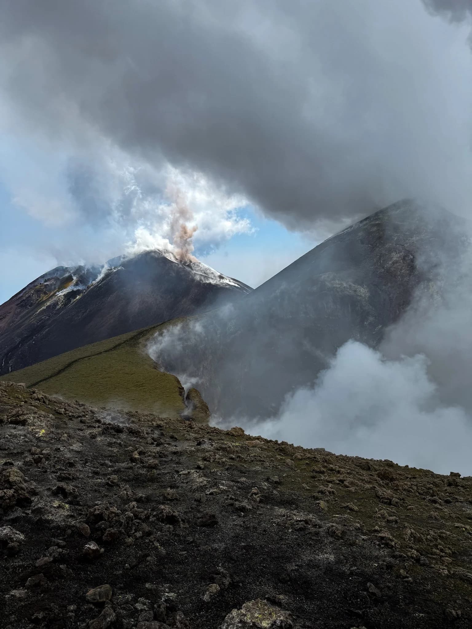 Colonna di cenere che si alza dietro la cresta del cratere